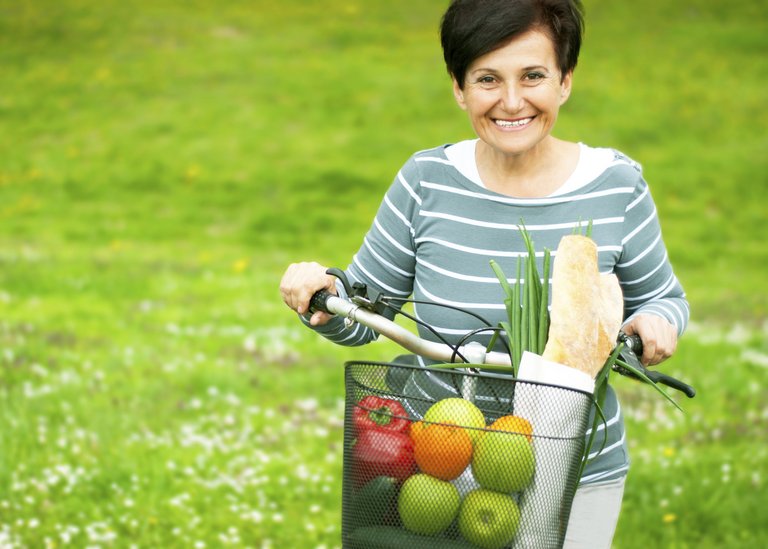 [Translate to Italy - Italian:] Woman on a bike with healthy food in the basket