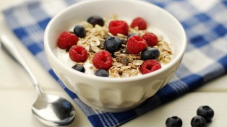 Tazza di muesli con fiocchi di avena, uvetta, frutta e yogurt. Selective focus.