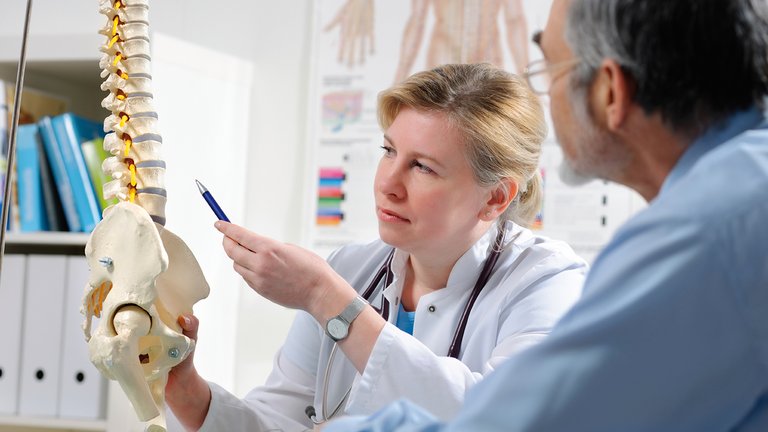 Medico spiega al paziente possibili complicanze della malattia ossea metabolica dovute a malattia renale cronica