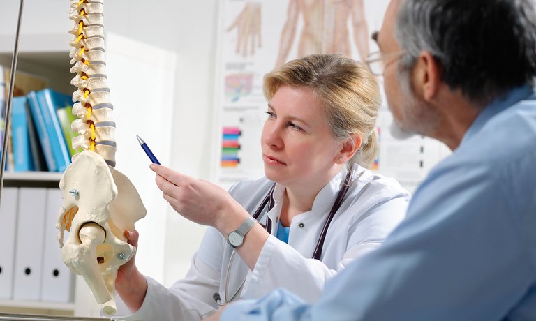 Medico spiega al paziente possibili complicanze della malattia ossea metabolica dovute a malattia renale cronica