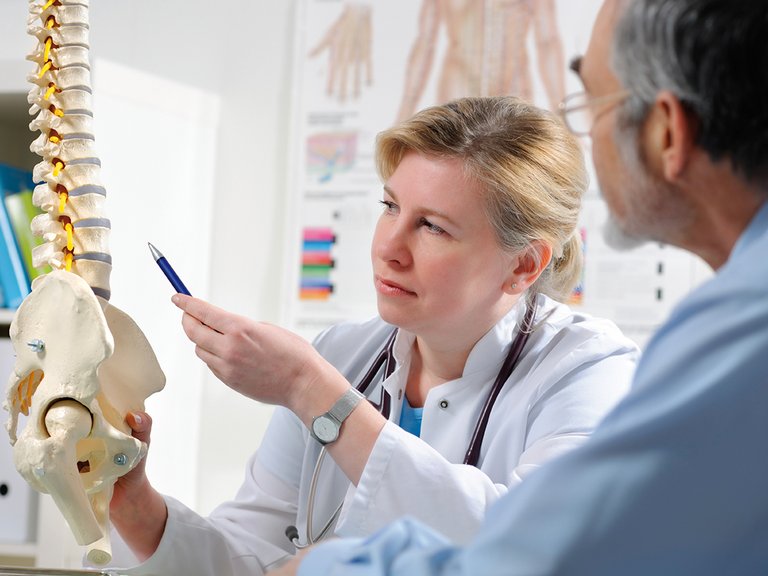 Medico spiega al paziente possibili complicanze della malattia ossea metabolica dovute a malattia renale cronica