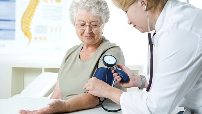 Medico mentre misura la pressione a una paziente